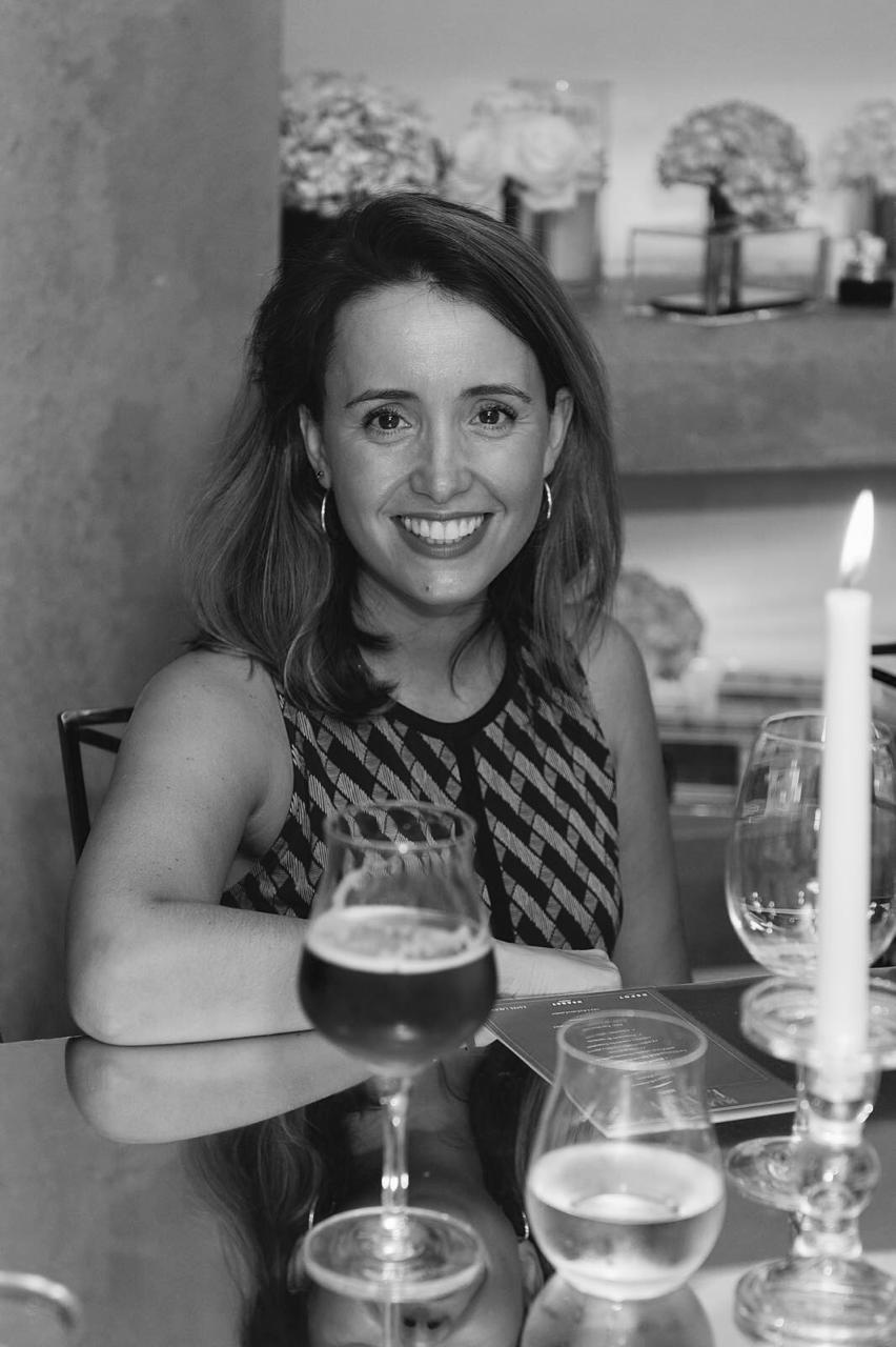 Paola Sáez de Montagut sentada a una mesa, en blanco y negro